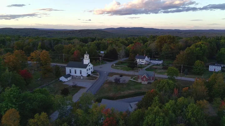 Dusk aerial view of Candia village crossroads, church and library, New Hampshire