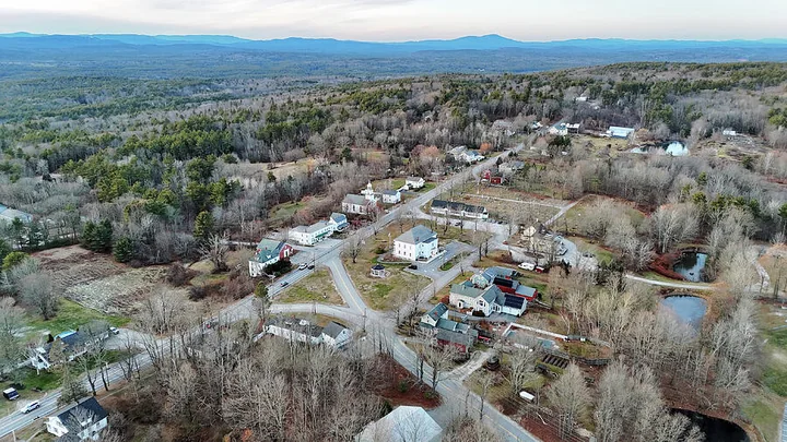 Aerial view of Dunbarton town common, village buildings and distant mountains, New Hampshire